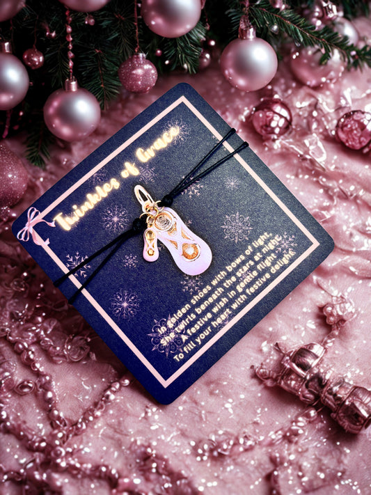 Bracelet with a pink and gold charm  on a decorative card surrounded by pink ornaments