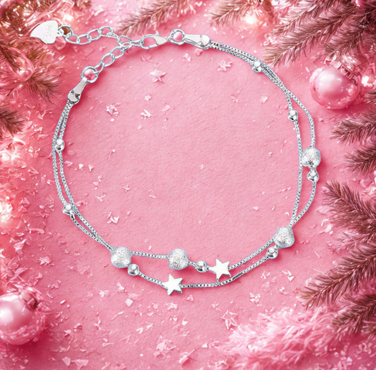 Silver bracelet with star-shaped beads on a pink background with decorative elements
