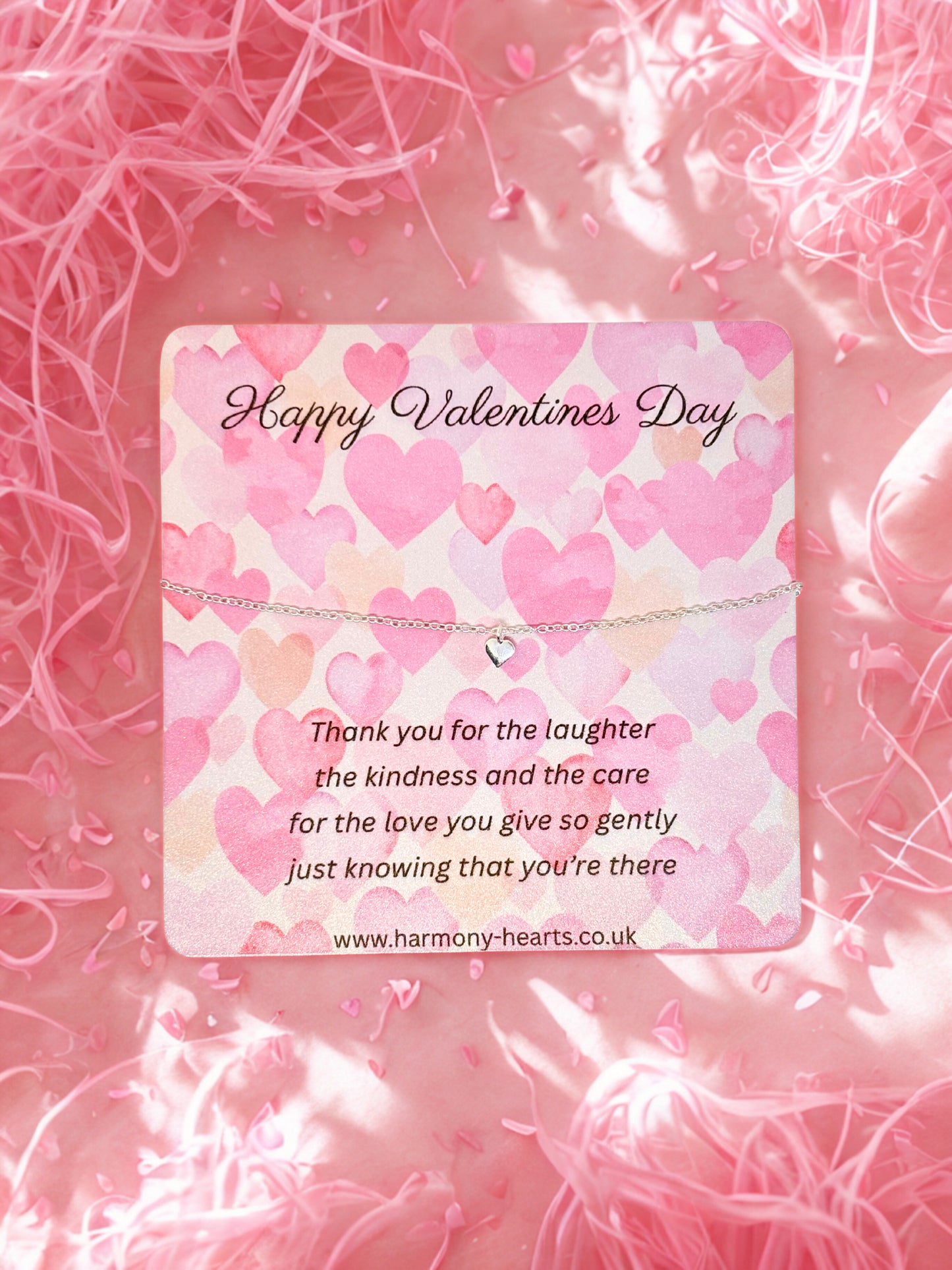 Valentine's Day card with a heart-shaped bracelet  on a pink textured background