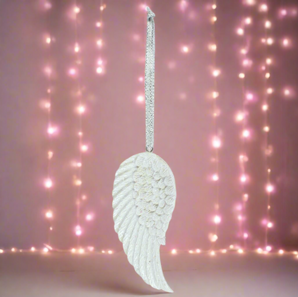 Decorative angel wing ornament with a pink string light background