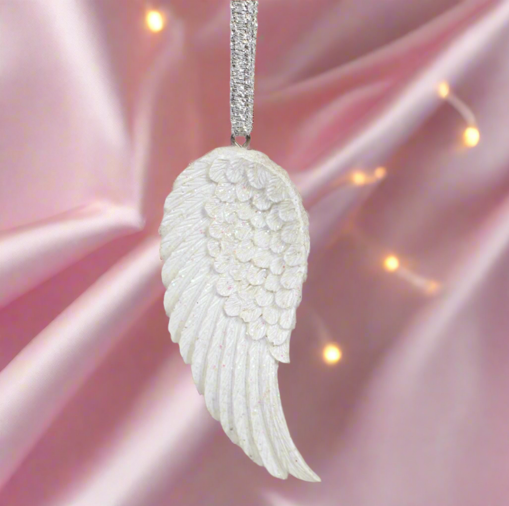 Angel wing pendant with diamond chain on a pink satin background