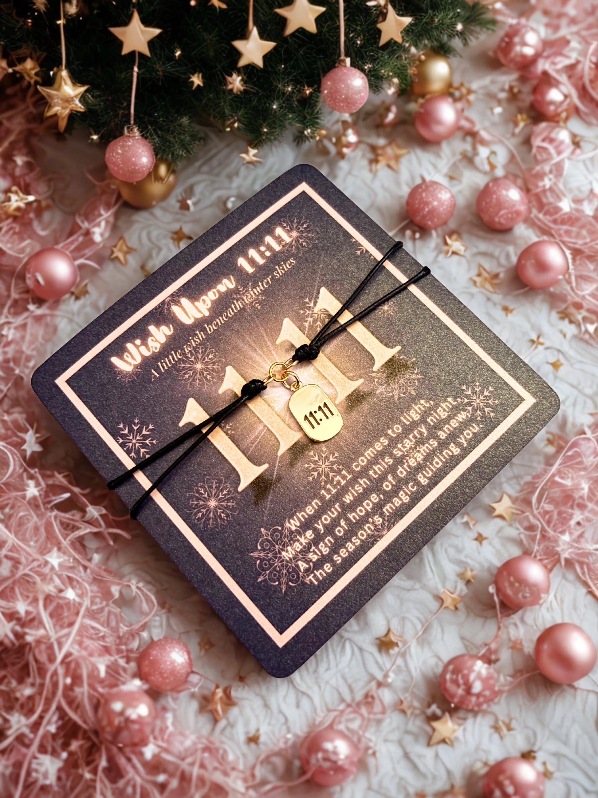 Gold 1111 charm bracelet on a festive poem card surrounded by pink Christmas decorations