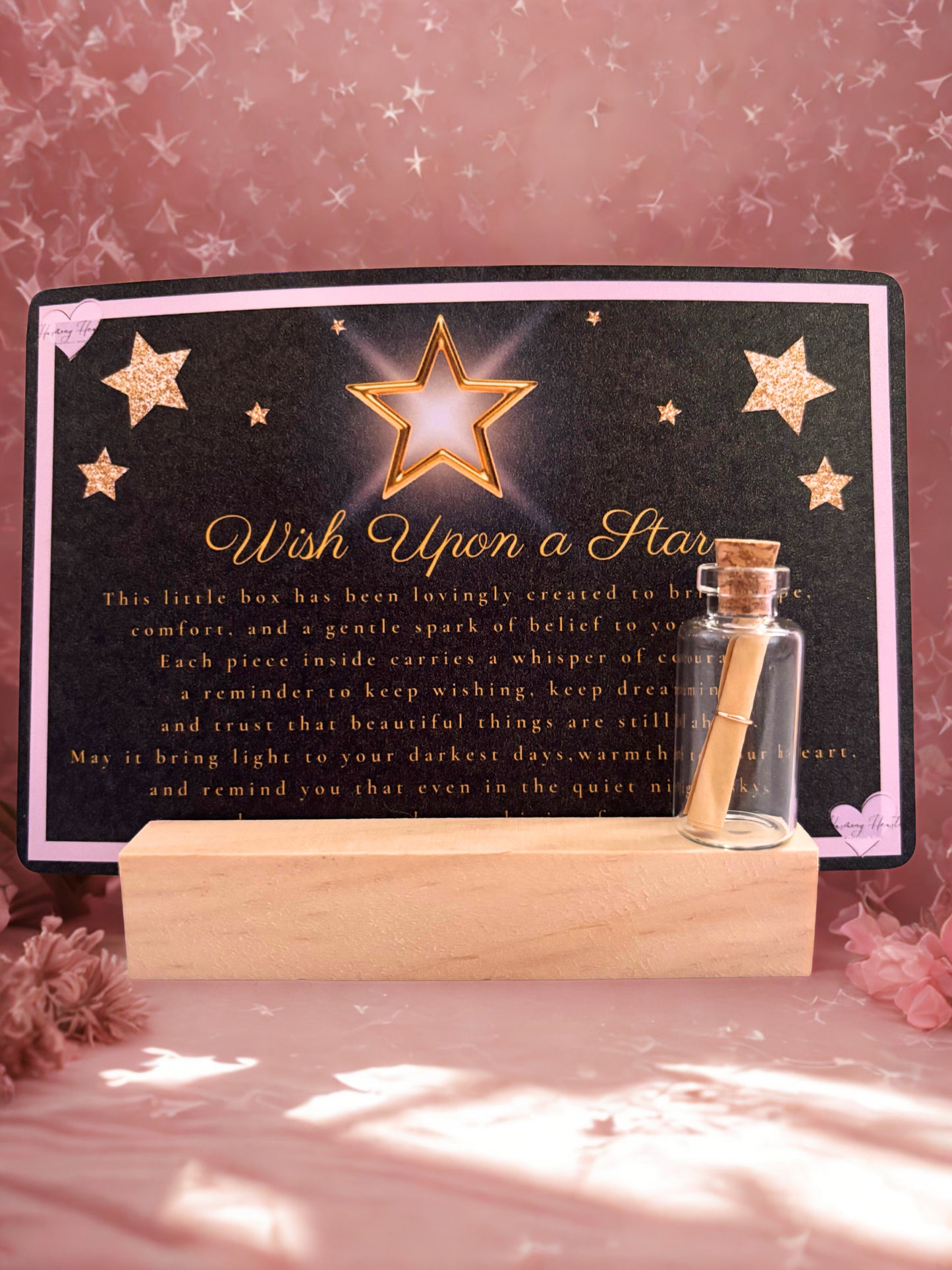 Decorative item with a star and text on a black background, placed on a wooden stand.
