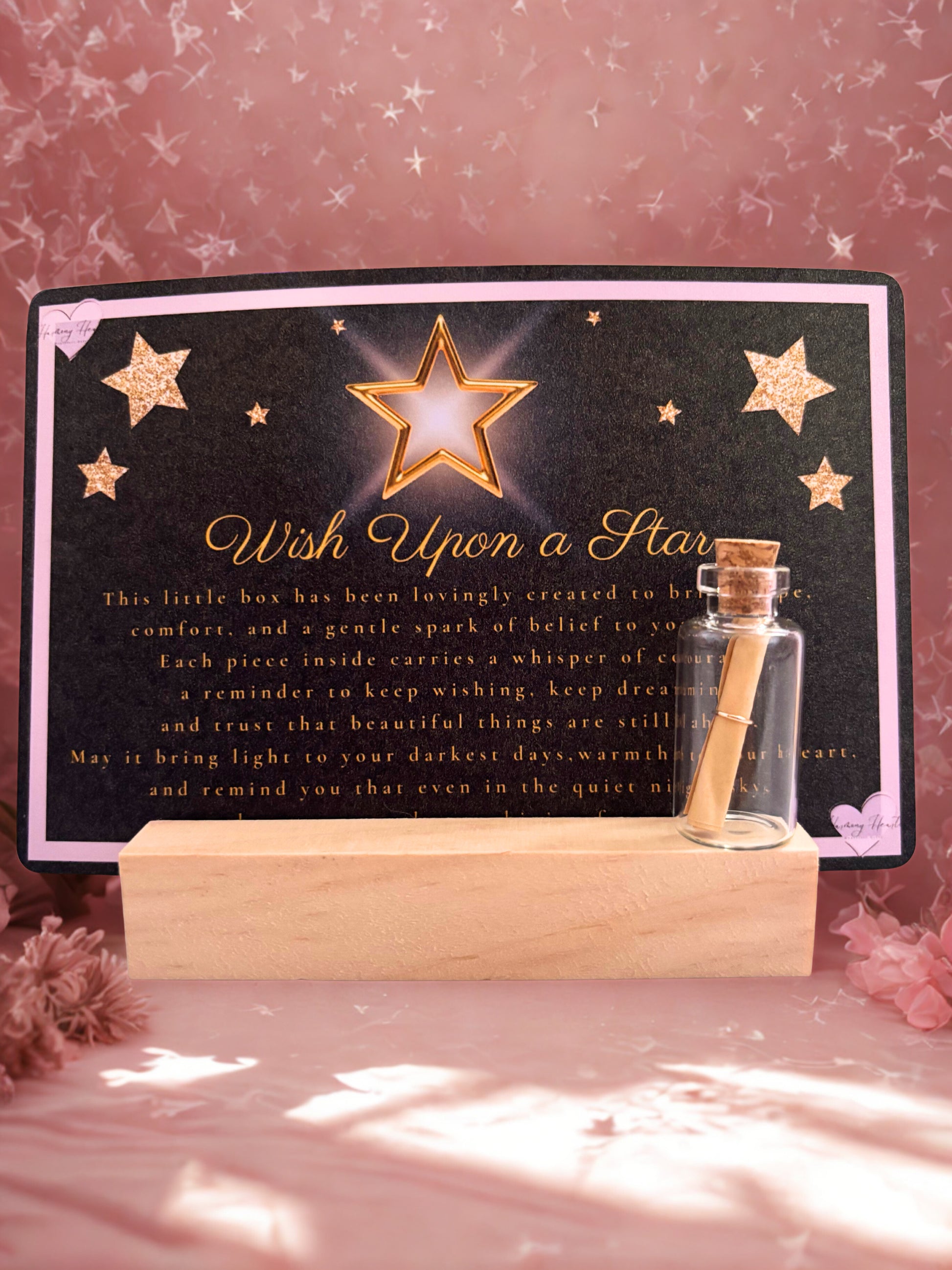Decorative item with a star and text on a black background, placed on a wooden stand.