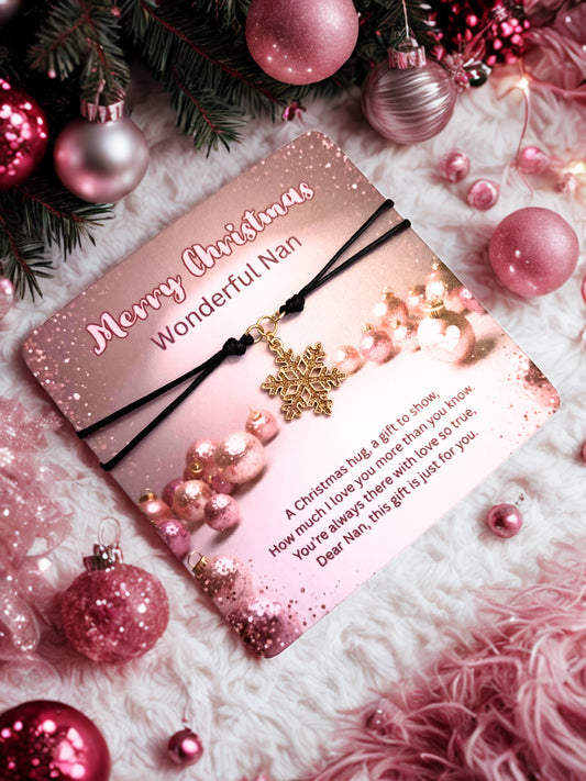 Pink card and snowflake bracelet with 'Merry Christmas Wonderful Nan' message, surrounded by pink ornaments and Christmas decorations.