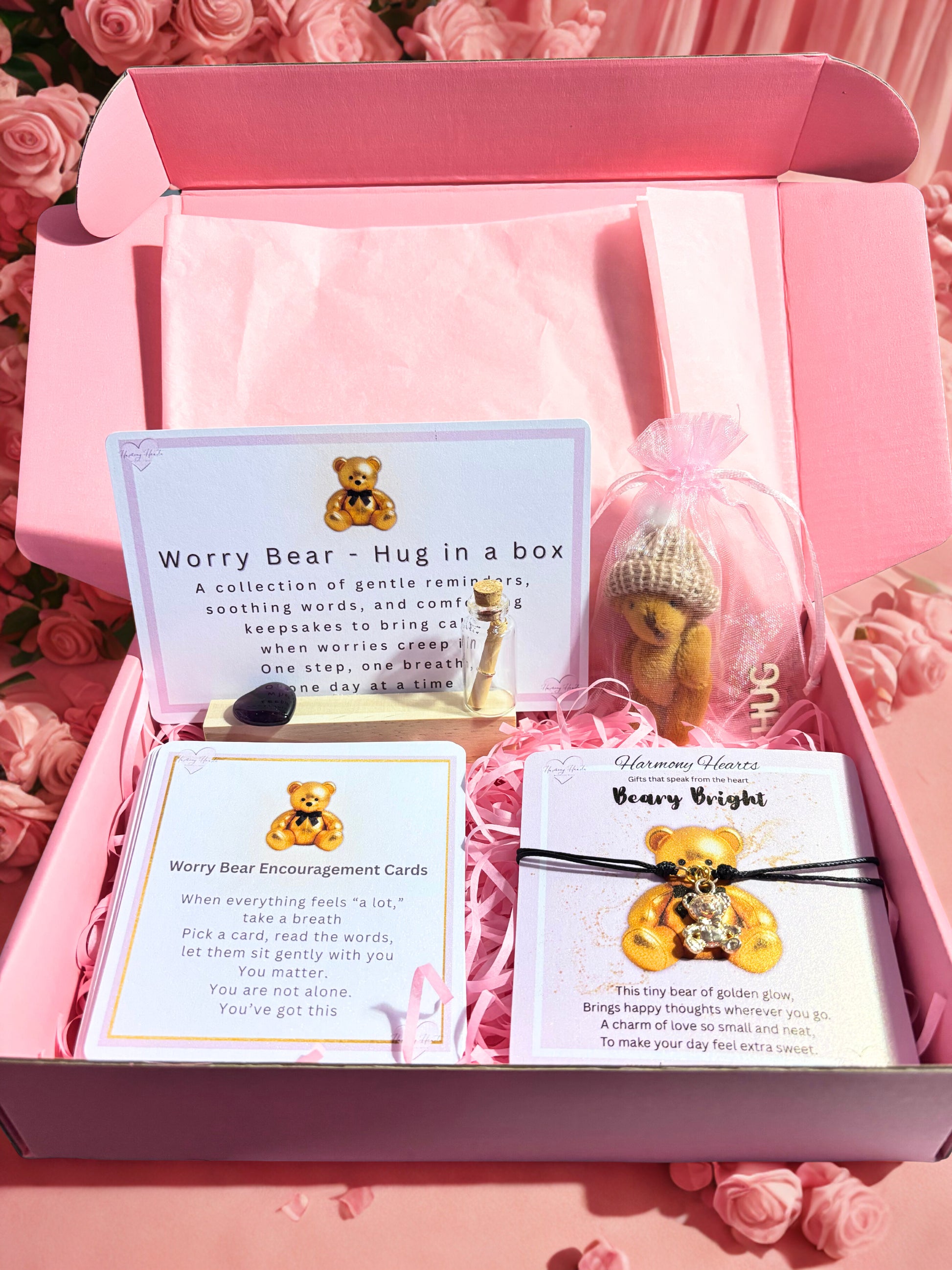 Pink gift box with 'Worry Bear' product, cards, and decorative elements on a pink background.