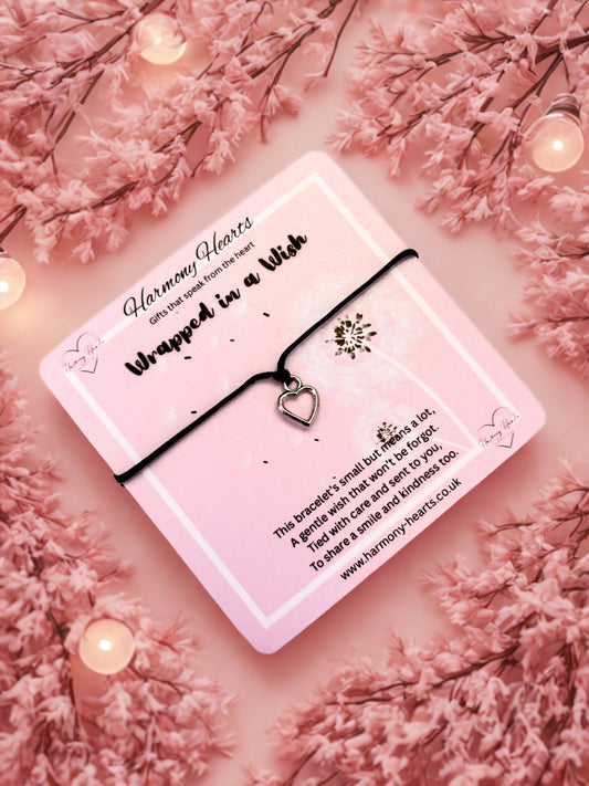 Heart bracelet on a pink Wrapped in a Wish poem card on a pink background with Harmony Hearts branding