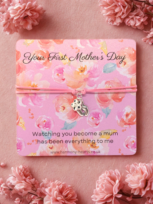 Charm bracelet on Floral-themed card with 'Your First Mother's Day' message on a pink background with flowers.